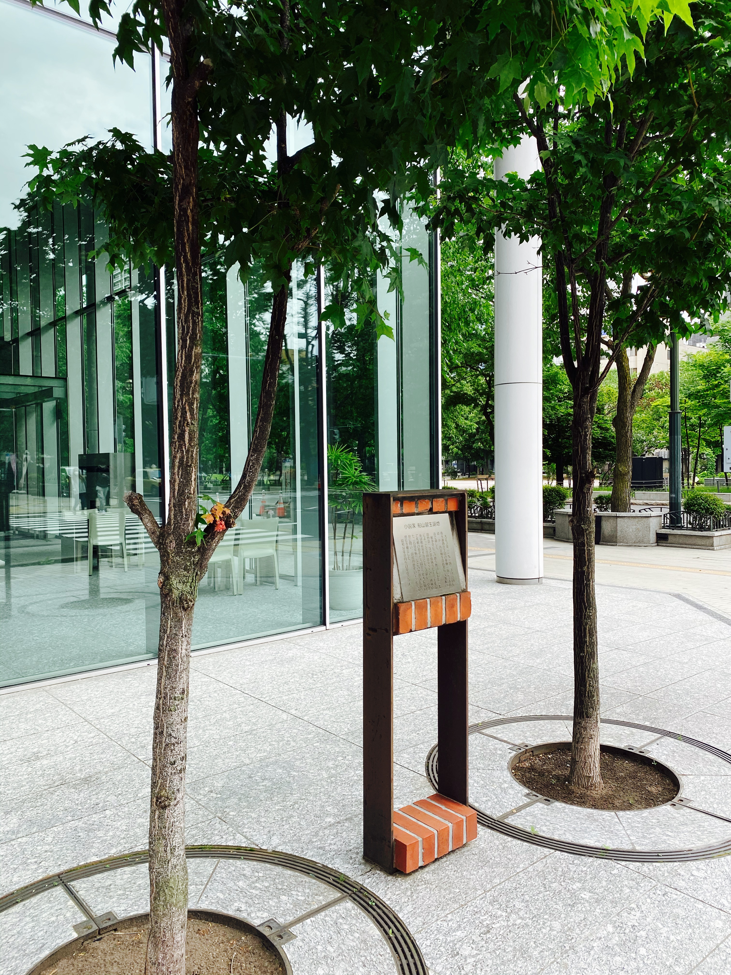 2本の街路樹に挟まれて立つ船山馨生誕地の文学碑