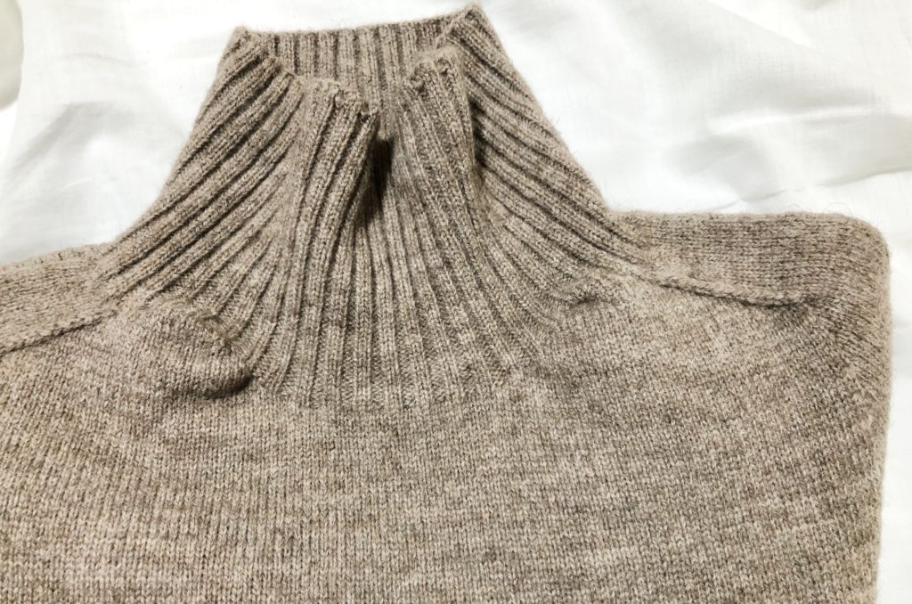 柔らかいベージュ色のタートルネックセーター