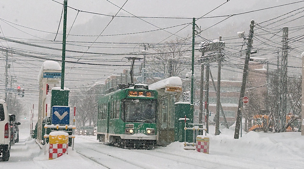 緑色の電車は降る雪の中でも映える。